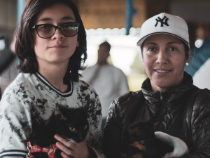Dos participantes del festival de mascotas, con un perro pequeño y un gatito.
