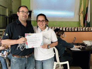 El rector P. Eduin y la profesora Rina Jaramillo en la entrega de un certificado de reconocimiento