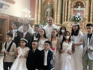 grupo de niños que realizo la Primera comunión en Bogotá con el rector del Cibercolegio