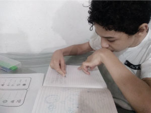 Estudiante de primaria incluyente, realizando en trabajo en su cuaderno