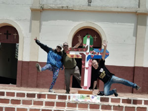 Rector de Cibercolegio y Coordinador de Calidad en Experiencia Ciber en frente iglesia municipio del Aro y cruz decorada