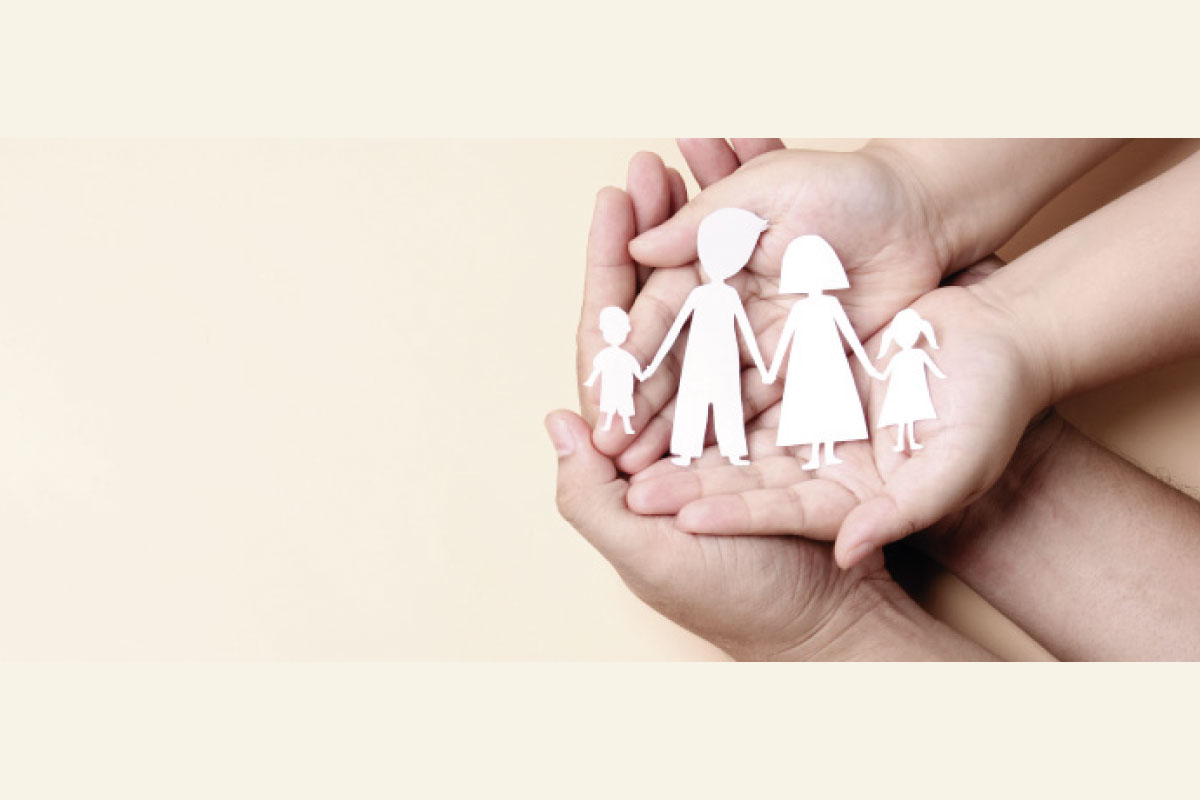 Imagen de varias manos sosteniendo una familia hecha en recorte de papel.