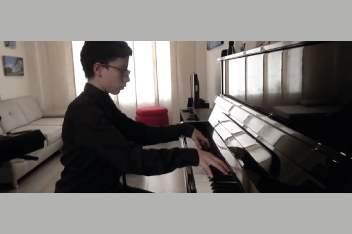 Fotografía de Matthew Garvin Díaz tocando el piano, el es estudiante del Cibercolegio y pianista, quien participó en el XIX Concurso de Jóvenes Solistas 2020. Este joven talento fue seleccionado ganador en la categoría de piano.