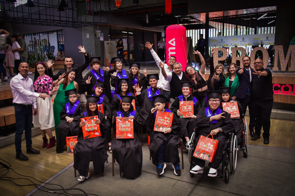 Fotografía de un grupo de graduados del Cibercolegio que usan togas y virretes. Algunos de ellos están sentados en sillas de ruedas.